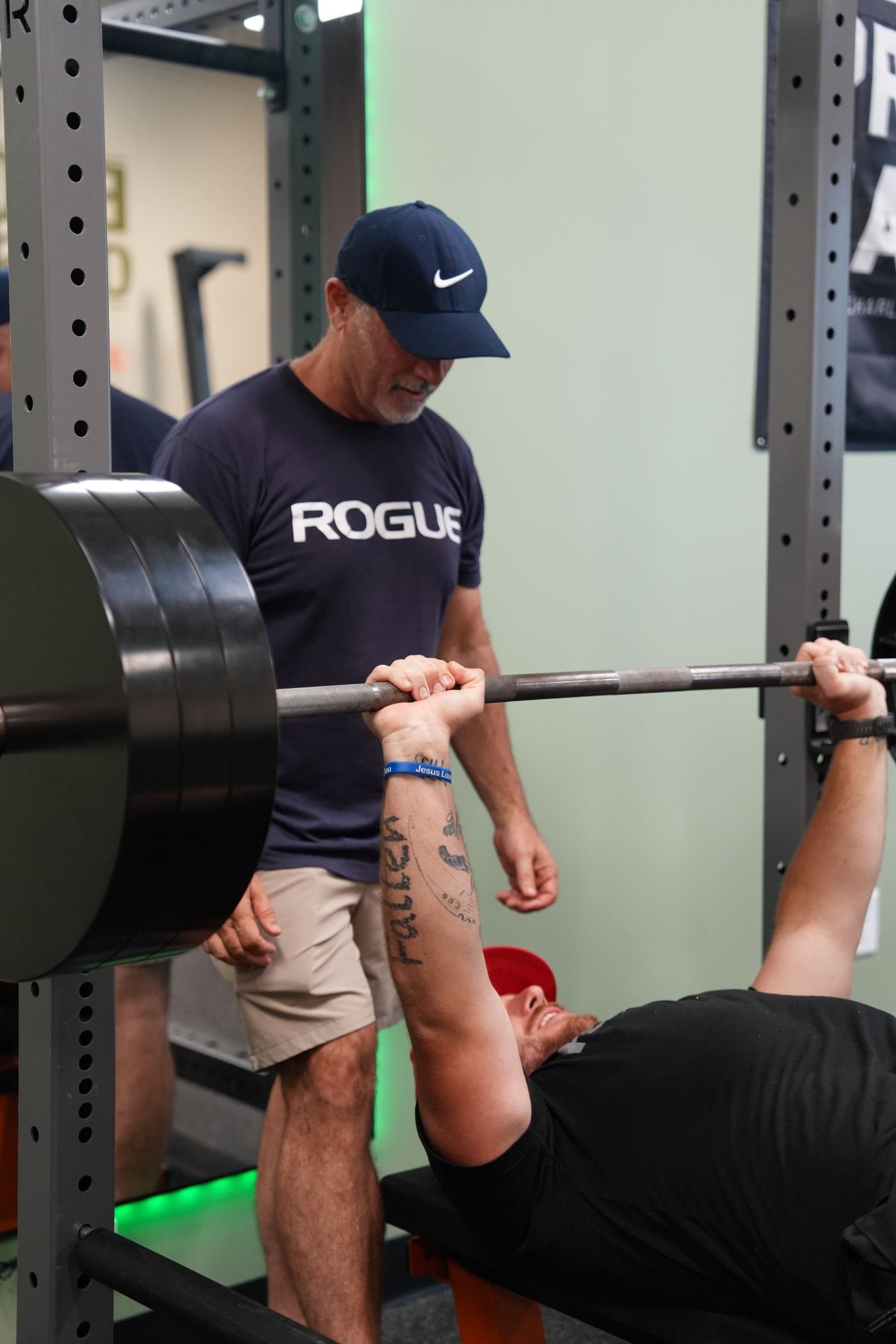 Coach Trevor Bicking spotting a member on the bench press at Elevate Barbell Club